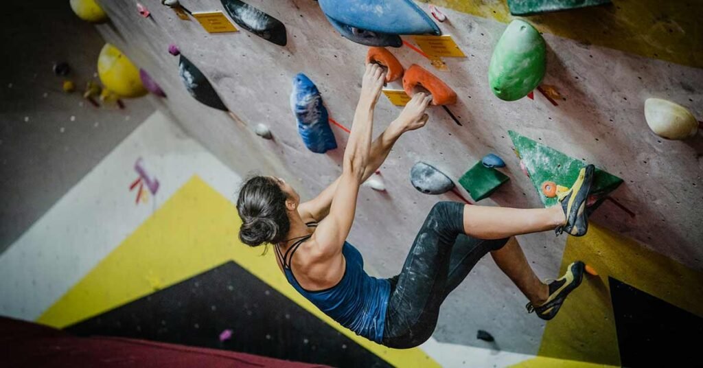 Mujer escalando en un rocodromo